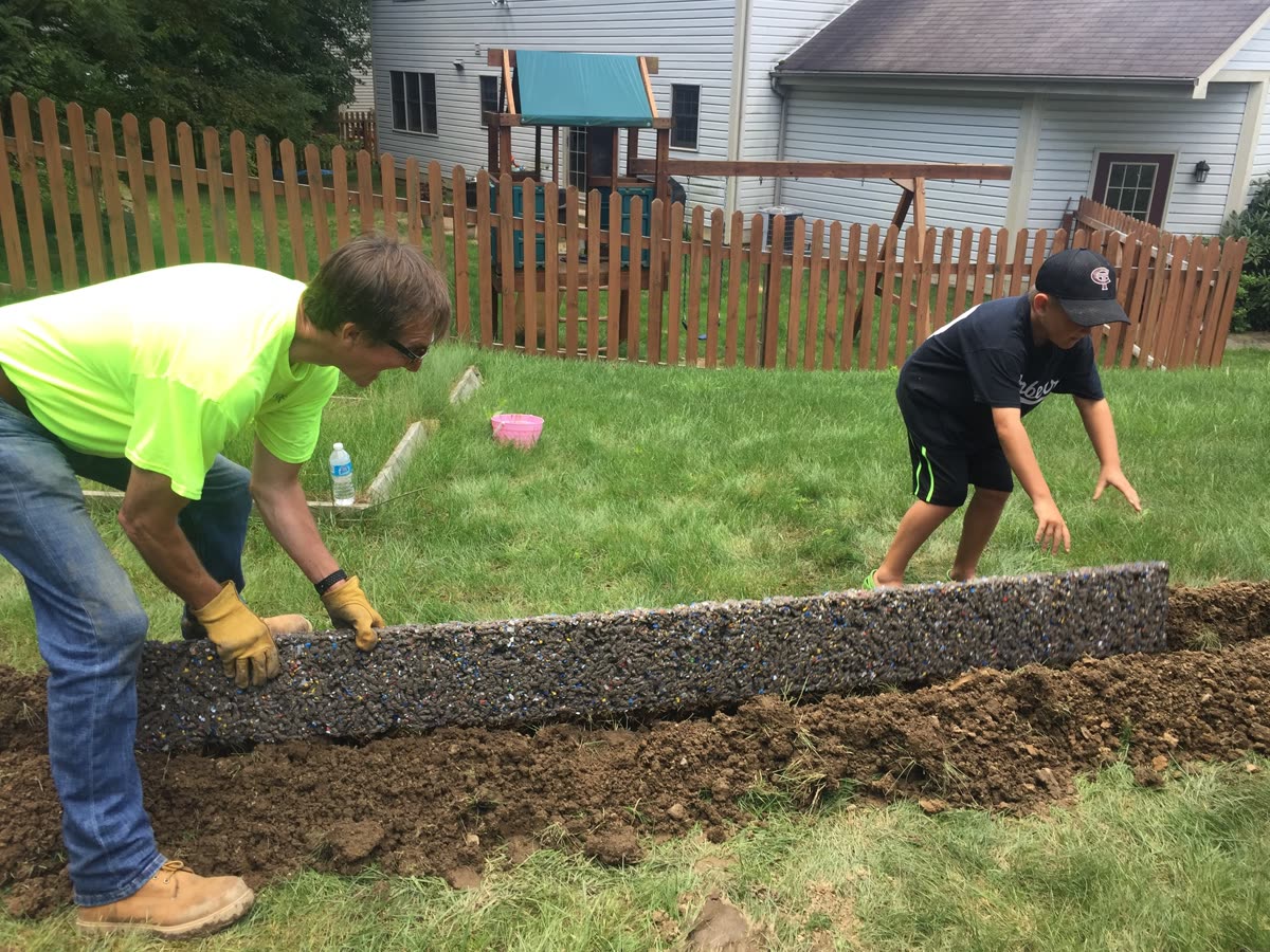 Hydro Ground Solutions crew installing pressure-fed drainage system in residential backyard Northwest Pennsylvania Pennsylvania